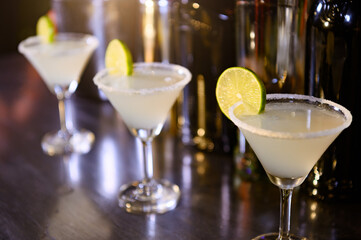 Closeup of lemonade drinks in martini glasses on bar in night club
