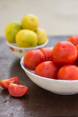 Red organic tomatoes and limes in blurry background