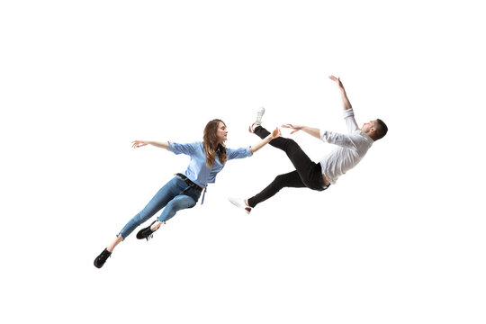 Mid-air beauty cought in moment. Full length shot of attractive young woman and man hovering in air and keeping eyes closed. Levitating in free falling, lack of gravity. Freedom, emotions, artwork