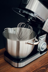silver Food Processor standing on wooden countertop on dark background