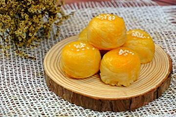 Delicious homemade Chinese pastries (mini moon cakes or bings) with mung bean and preserved egg yolk served in wooden tray.