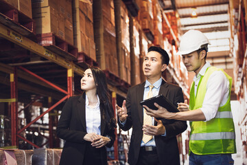Asian male foreman or manager showing report from digital tablet to business man and woman or CEO...