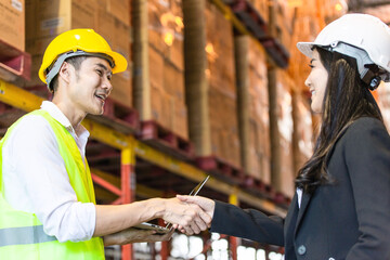 Asian business woman shaking hand with male construction worker for dealing contract agreement in...