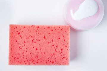 bathing sponge and liquid soap. Means for bathing in the bathroom. Photo above