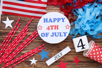 Fototapeta premium Text Happy 4th of July with flag, stars, cups and cube calendar on wooden background