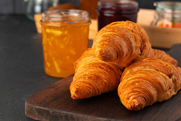 Fresh croissants on wooden board close up