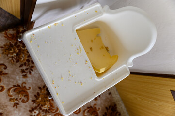 White children's dining chair with foam for sitting full of crumbs.