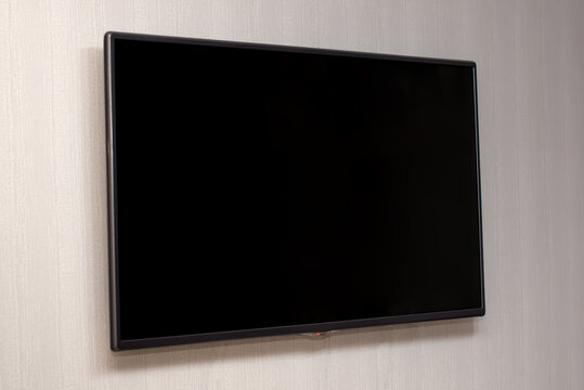 Large flat screen TV hanging on the wall, a TV with a black screen,turning off the TV