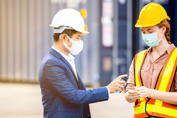 Industrial worker wear hygienic mask  and infrared thermometer at logistic warehouse container...