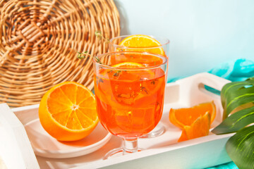 Glass and bottle with fresh homemade orange sweet iced tea or cocktail, lemonade with thyme. Refreshing cold drink. Summer party.