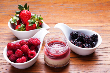 Nutrition concept - Healthy cheese cake in glass jars over wooden background. Healthy food, Diet, Detox, Clean Eating or Vegetarian concept. Delicious dessert option.