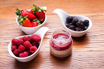 Nutrition concept - Healthy cheese cake in glass jars over wooden background. Healthy food, Diet, Detox, Clean Eating or Vegetarian concept. Delicious dessert option.