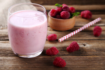 Raspberry smoothie in glass on brown wooden table
