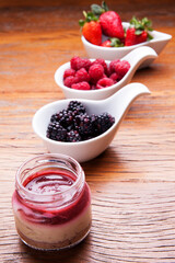 Nutrition concept - Healthy cheese cake in glass jars over wooden background. Healthy food, Diet, Detox, Clean Eating or Vegetarian concept. Delicious dessert option.