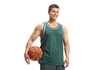 Basketball player in a jersey holding a ball and smiling at the camera