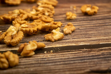 Peeled walnuts scattered on a wooden table. Healthy diet. Fitness diet. Close up.