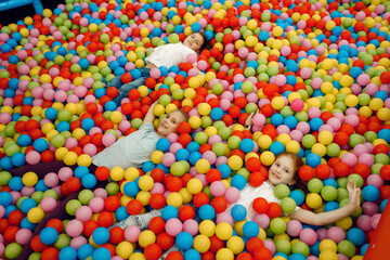 Fototapeta na wymiar Children lying among many balls, playground