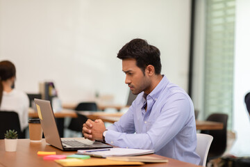 Fototapeta na wymiar Portrait of Young business indian man working with laptop at office