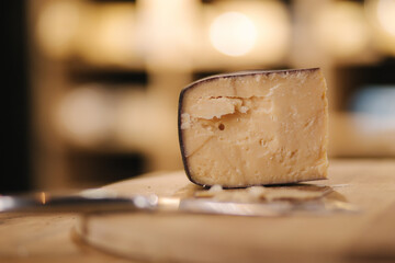 Aged cheese on wooden board. Cheese knife