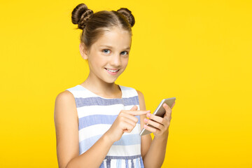Naklejka premium Young beautiful girl with mobile phone on yellow background