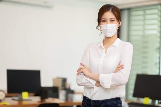 Asian Business Women Leader Wearing Mask Protection Virus Standing Smile Cross Arm And Confidence At Co-Working Space Due Covid-19 Flu Pandemic,Health Care And Business Startup Concept