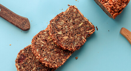 Sliced whole grain bread rye with seeds flax, sunflower, pumpkin and sesame.Healthy food, eco-friendly natural products. Fresh bread on a pink background.