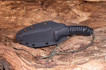A knife with a fixed blade in a plastic sheath. Kaydeks scabbard.