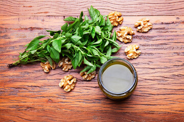 Nutrition concept - Healthy sauce of Homemade parsley pesto sauce and ingredients in glass jars over wooden background. Healthy food, Diet, Detox, Clean Eating or Vegetarian concept