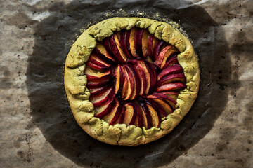 Peach galette on baking paper, top view