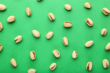 Tasty pistachios on green background