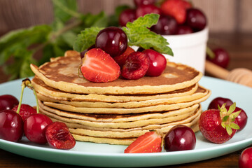 Breakfast. Pancakes with berries on a wooden background