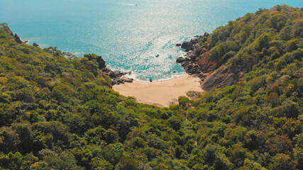 Beautiful secret beach Butterfly in Goa, India. Aerial view of pristine beach with rocky bay and waves crashing. © Довидович Михаил