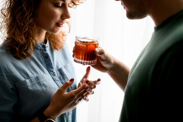 man neatly holds out glass with cocktail to young beautiful woman.