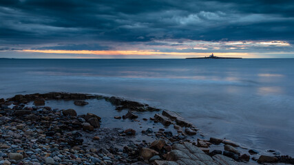 Sunrise at Hauxley Beach on the coast of Northumberland, England UK, with Coquet Island in the...