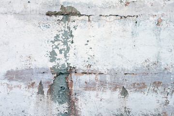 A concrete wall with cracks and peeling paint. Texture, material for the design. Background.