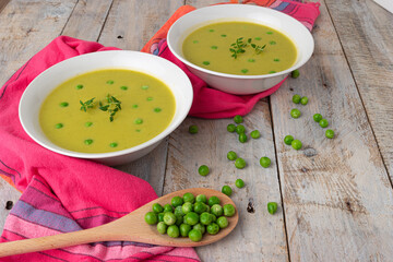 Fresh green pea soup with pea seeds. Cream soup of green peas. A delicious lunch in a rustic style