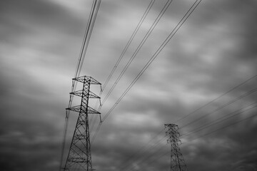 Dramatic Close-up transmission towers (power tower, electricity pylon, steel lattice tower) cloud dark sky in New Zealand.