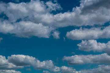 A cluster of white clouds on a bright sunny day, the sky is azure in color.