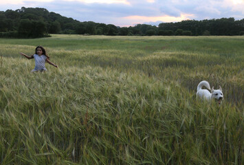 girl and dog running in a field