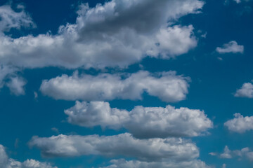 Obraz premium A cluster of white clouds on a bright sunny day, the sky is azure in color.