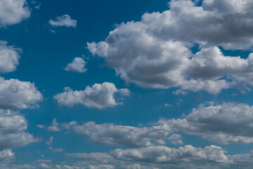 A cluster of white clouds on a bright sunny day, the sky is azure in color.