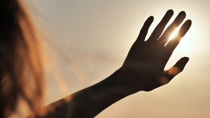 The girl touches the sunset sun the fingers. Romantic concept.