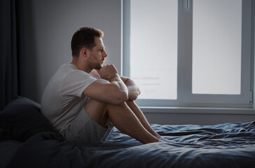 Anxious Man Thinking About Problems Sitting In Bed Indoors