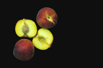 peaches on a black background, Fruits of organic peaches whole and halves