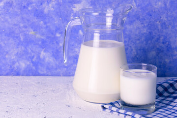 Milk in a jug on a light blue background. Copy space.