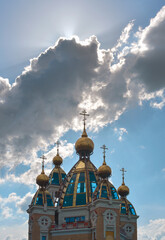 Fototapeta na wymiar Orthodox church under a cloud against a bright blue sky