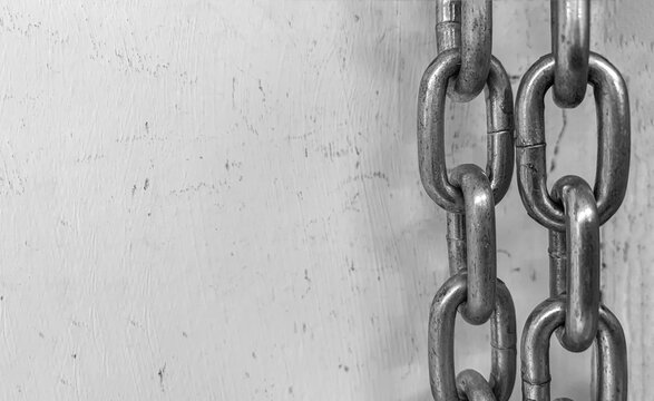 Large chain links on a gray background. The concept of bondage and restriction of freedom. Slavery. Free space for text.