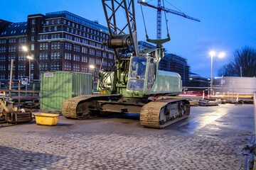 Naklejka premium ein grüner Kran mit Kettenräder auf einer Baustelle