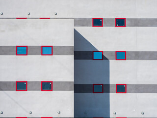 Fototapeta na wymiar Fachada de edificio de oficinas de estilo contemporáneo con ventanas de marco rojo