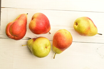 Sweet juicy pears, close-up, on a white wooden table.